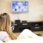 Young woman watching TV in the room