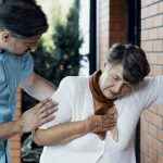 Male nurse helping sick elderly woman with chest pain