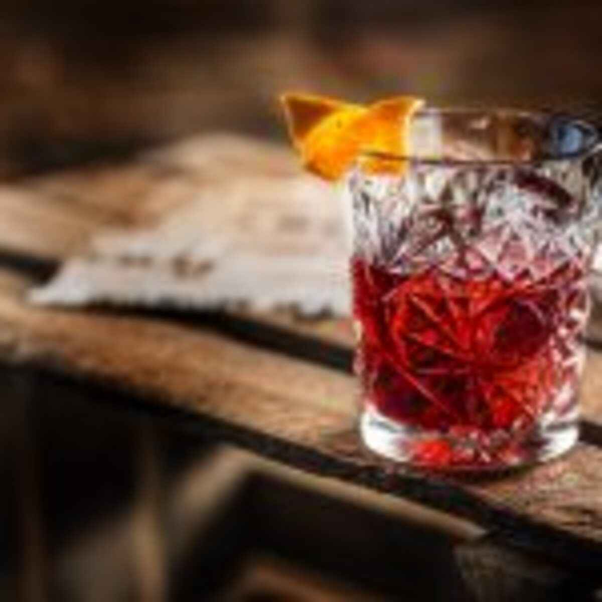 Cocktail Negroni on a old  wooden board. Drink with gin, campari martini rosso and orange