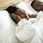 A couple sleeping while the man is snoring