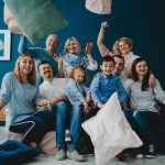 Grandparents, parents and their little children sit together on