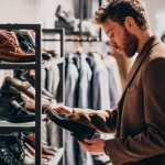 hombre-guapo-joven-que-elige-zapatos-tienda_1303-19707
