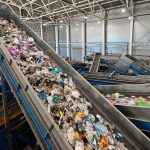 Trash transported by conveyor in recycling plant workshop