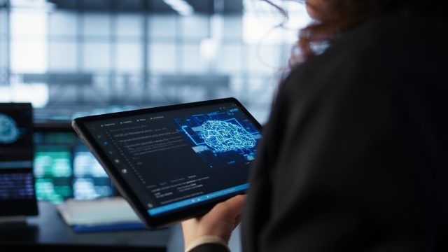 Data center technician using artificial intelligence on tablet, close up
