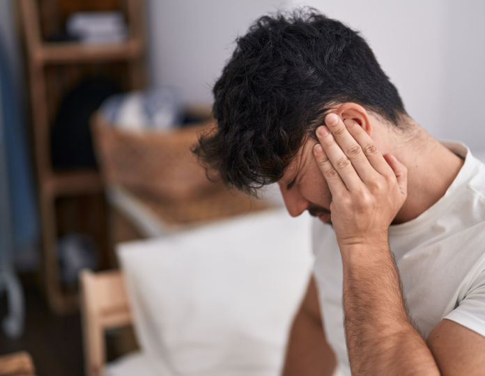 jovem-hispanico-sofrendo-de-dor-nas-costas-sentado-na-cama-no-quarto (1)