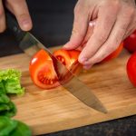 Male hands cutting vegetables for salad