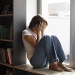 portrait-young-woman-with-low-self-esteem-sitting-by-window-home