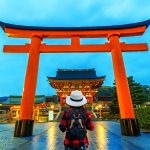 Woman traveler with backpack at fushimi inari taisha shrine in K
