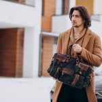Young handsome business man walking out of the house to his car